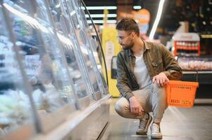 Handsome man shopping in a supermarket photo