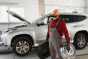 mecánico trabajando y participación llave inglesa de Servicio orden para mantener coche a el reparar tienda foto