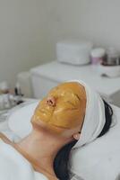 A girl at a cosmetologist does cosmetic procedures. Alginate mask photo