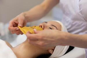 A girl at a cosmetologist does cosmetic procedures. Alginate mask photo