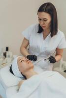 Cosmetologist esthetician performs skin treatment and rejuvenation photo