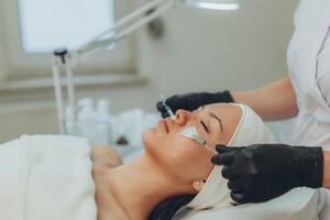 woman at the cosmetologist. She has problem skin and acne. photo