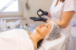 woman at the cosmetologist. She has problem skin and acne. photo