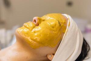 A girl at a cosmetologist does cosmetic procedures. Alginate mask photo