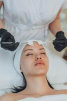 A girl at a cosmetologist does cosmetic procedures. Skin cleansing photo