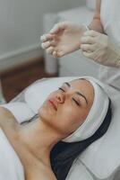 girl at a cosmetologist's office doing skin cleansing photo