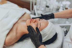 A girl at a cosmetologist does cosmetic procedures. Skin cleansing photo