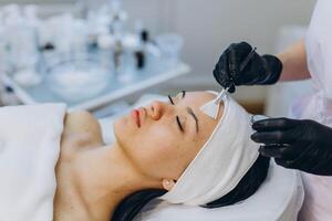 A girl at a cosmetologist does cosmetic procedures. Skin cleansing photo