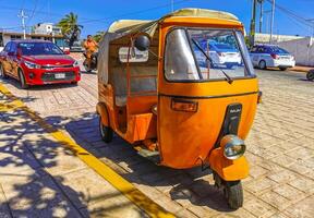 Puerto Escondido Oaxaca Mexico 2023 Orange tuk tuk tricycle TukTuks rickshaw in Mexico. photo