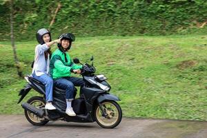 asiático en línea Taxi motocicleta pasajero señalando un sitio foto