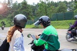 Online Driver Showing Phone Application to Female Customer photo