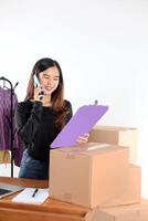 Asian Female Small Business Owner, Happy Face While Calling using Smartphone photo