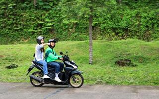 Asian Online Driver with Female Passenger Pointing photo