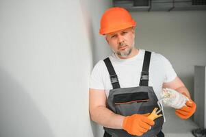 Painter using a paint roller and painting a wall isolated on white background. photo