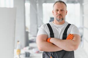 Portrait of a builder in the process of working on a construction site indoors photo