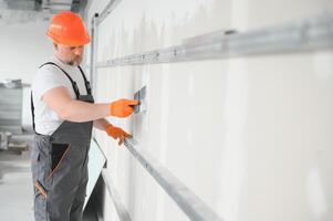 apartment interior construction - worker plastering gypsum board wall photo