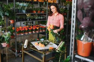 joven hermosa mujer florista hacer ramo de flores de flores a flor tienda foto