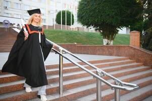 A young female graduate against the background of university. photo