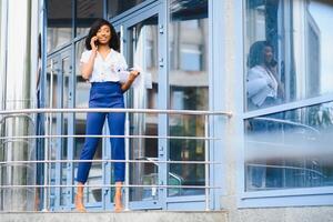 A pretty African american business woman talking on a cell phone at office building photo