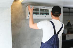 specialist cleans and repairs the wall air conditioner photo