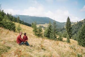 Father and child hiking in scenic mountains. Dad and son enjoying the view from the mountain top in Carpathian mountains photo