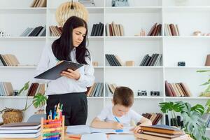 tutor deals with the preschooler with a laptop, a real home interior, the concept of childhood and learning photo