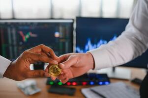 View of hand holding a bitcoin and giving it to other people. Cryptocurrency trading concept photo