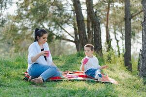 Happy young mother is playing with her baby in a park on a green lawn. Happiness and harmony of family life. Great family vacation. Good weekend. Mothers Day. Holiday. The concept of a happy family photo