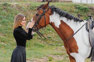 Fashionable portrait of a beautiful young woman and horse photo