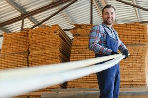 Timber harvesting for construction. Carpenter stacks boards. Industrial background. Authentic workflow. photo