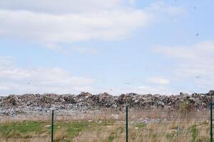 enorme pila de basura en un ciudad tugurio en melancólico día. acuerdo el ambiente limpio. ecológico problemas. foto