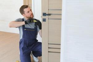 handsome young man installing a door in a new house construction site. photo