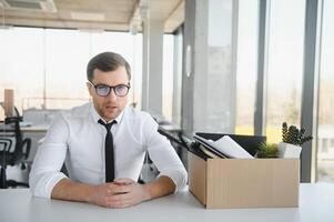 business, firing and job loss concept - fired male office worker with box of his personal stuff. photo