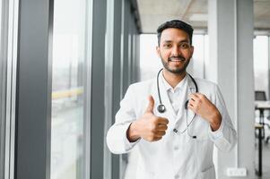 Portrait of confident Asian Indian medical doctor standing at hospital building photo