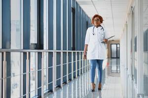 Pretty young African American medical professional standing and looking at camera in a hospital. photo