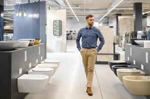 en un plomería almacenar, un hombre elige un nuevo baño cuenco foto