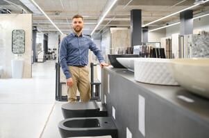 Portrait of salesperson in bathroom store. Happy man works in bath store. Sales occupation photo