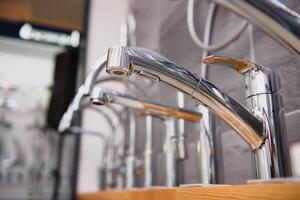 showcase in the store with faucets for the kitchen and bathroom photo