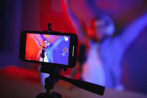 A video blogger records content in his studio. The backstage photo was taken from behind one of the participants in the shooting, at the beginning of the shooting when the blogger is preparing.