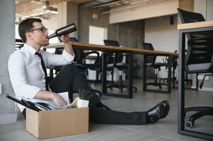 Business, stress and alcoholism. Depressed businessman drinking alcohol in front of corporation after got fired. Business concept photo