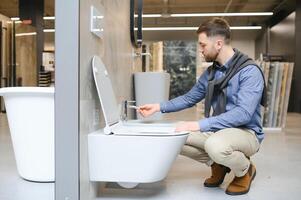 Man choosing home toilet in store photo