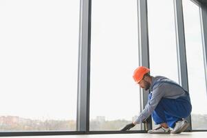 Worker installing plastic window indoors. photo