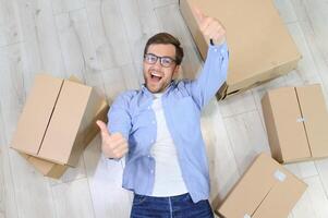 Happy man with cardboard box in new home photo