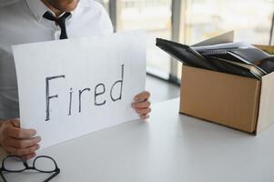 fired employee holding fired sign in hand photo