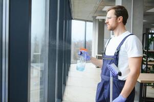 Male worker washing window glass photo