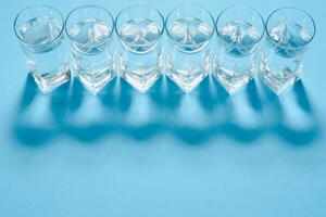 Glasses of clean water on color background photo