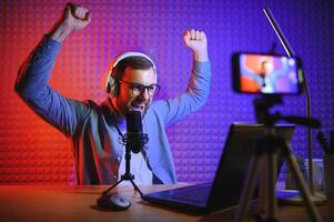 A video blogger records content in his studio. The host of the video blog is a young man who is very enthusiastic about telling his subscribers a story. photo