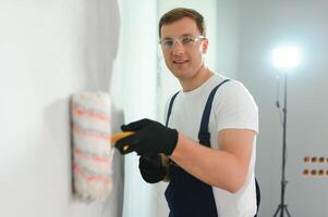 repair, building and home concept - close up of male in gloves holding painting roller photo