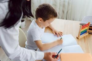 Tutor with pupil. Little boy studying. Private lesson. The concept of private lessons and homework. photo