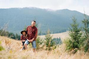 Happy father and little child are walking in the mountains. Father's Day. vacation in the national park photo